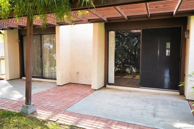 doorway to property featuring a patio area and a pergola