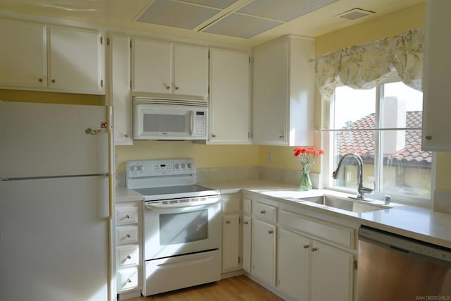 kitchen featuring white cabinetry, sink, light hardwood / wood-style floors, and white appliances