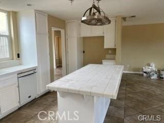 kitchen with a kitchen island, white cabinetry, hanging light fixtures, tile countertops, and white dishwasher