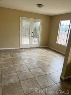 unfurnished room featuring light tile patterned flooring and french doors