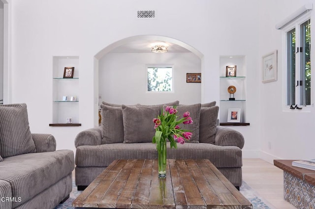 living room featuring built in features and light wood-type flooring