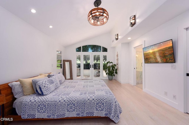 bedroom with vaulted ceiling, light hardwood / wood-style floors, french doors, and ensuite bath