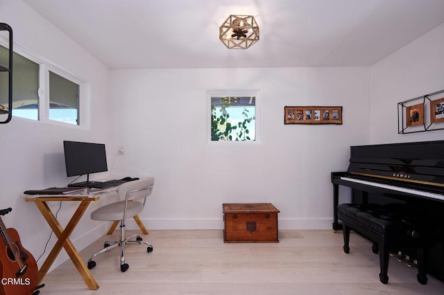 office space featuring plenty of natural light and light hardwood / wood-style flooring