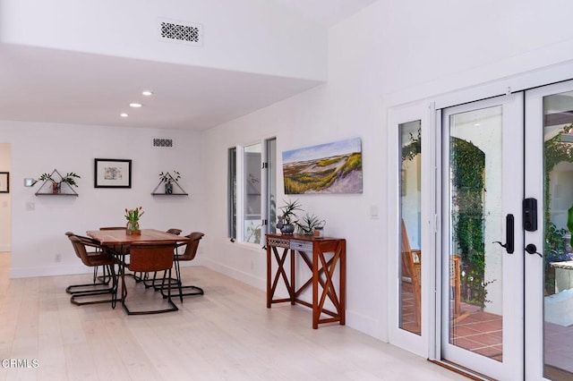 dining area with light hardwood / wood-style floors, french doors, and a healthy amount of sunlight