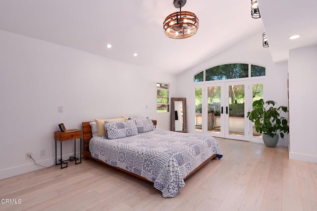 bedroom featuring access to exterior, lofted ceiling, light hardwood / wood-style floors, and french doors