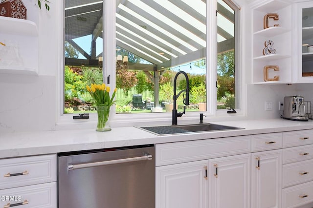 kitchen featuring white cabinetry, dishwasher, light stone countertops, vaulted ceiling, and sink