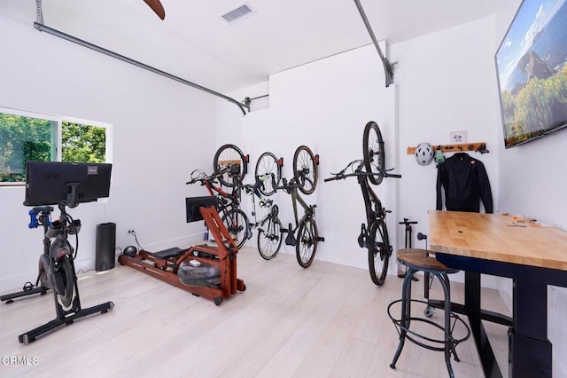 exercise room featuring light wood-type flooring