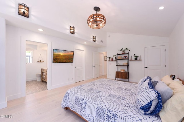 bedroom featuring ensuite bathroom, lofted ceiling, and light hardwood / wood-style floors