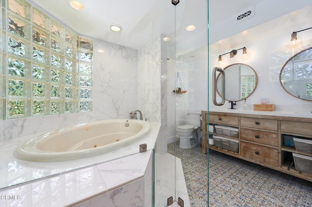 bathroom featuring tiled bath, toilet, and vanity