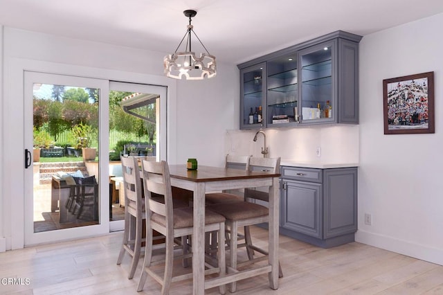 dining area with light hardwood / wood-style flooring and a notable chandelier