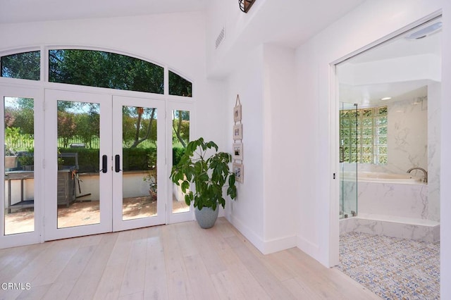 doorway with light wood-type flooring and french doors