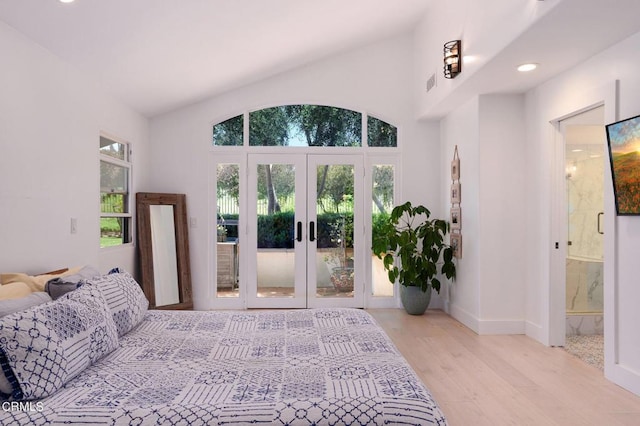 bedroom featuring access to outside, light hardwood / wood-style flooring, lofted ceiling, and french doors