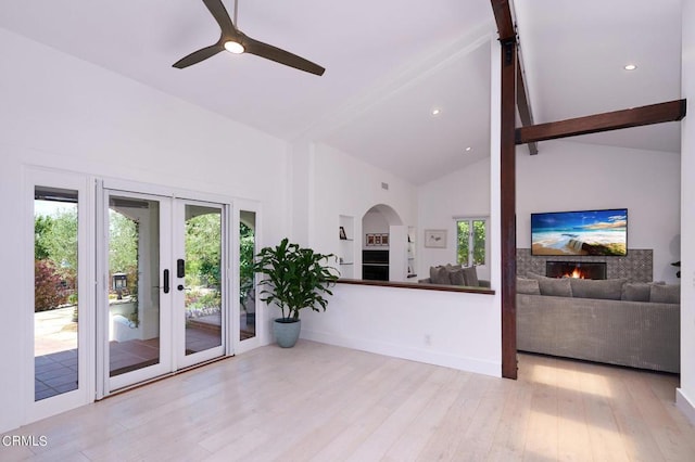 living room featuring ceiling fan, light hardwood / wood-style flooring, french doors, and high vaulted ceiling