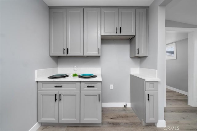 kitchen with gray cabinetry and light hardwood / wood-style flooring