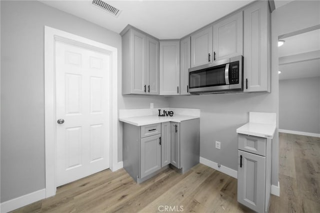 kitchen with light wood-type flooring and gray cabinetry