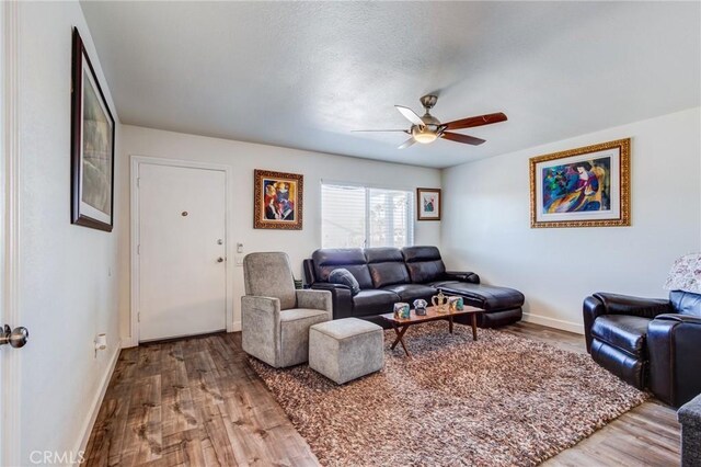 living room featuring ceiling fan and hardwood / wood-style flooring