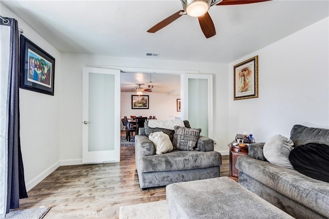 living room with ceiling fan, french doors, and light hardwood / wood-style flooring