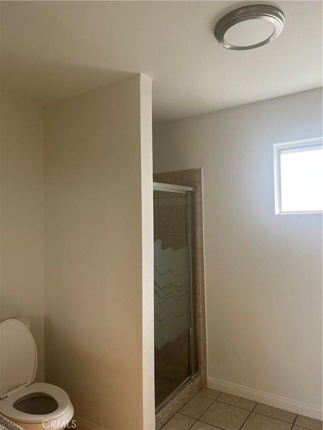 bathroom with toilet, a shower with shower door, and tile patterned flooring