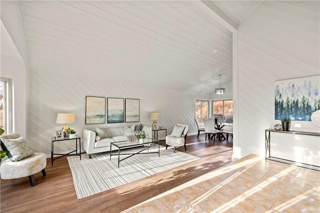 living room featuring high vaulted ceiling, wooden walls, and hardwood / wood-style floors