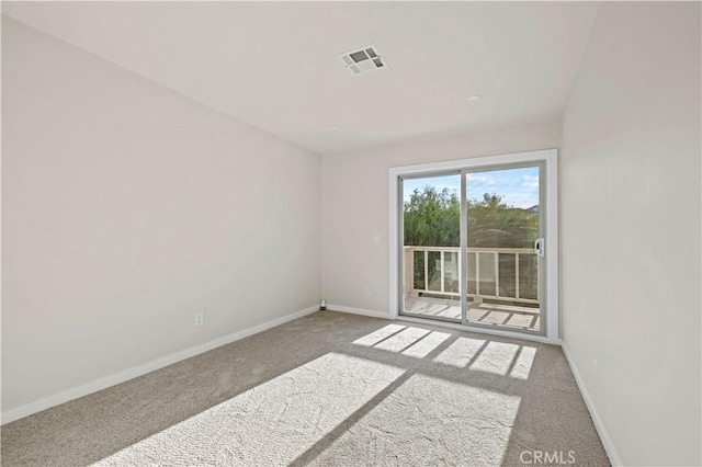 spare room featuring visible vents, baseboards, and carpet