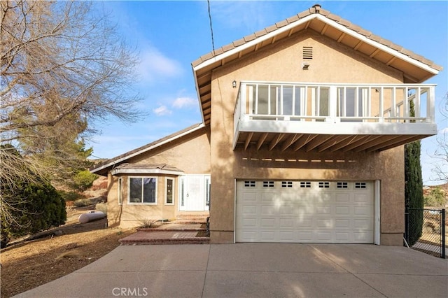 view of front of house featuring stucco siding, an attached garage, concrete driveway, and a balcony