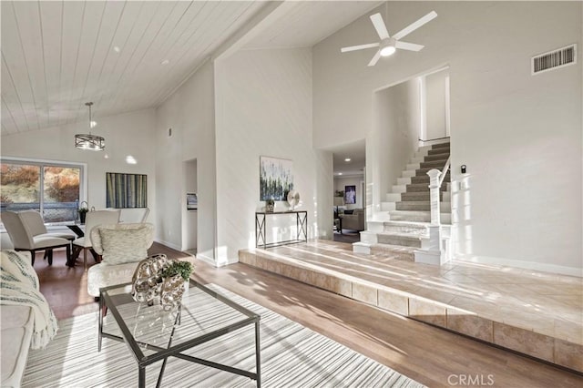 living room with visible vents, wood ceiling, stairs, wood finished floors, and a ceiling fan