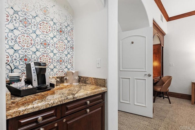 bar featuring dark brown cabinetry, crown molding, and light stone counters