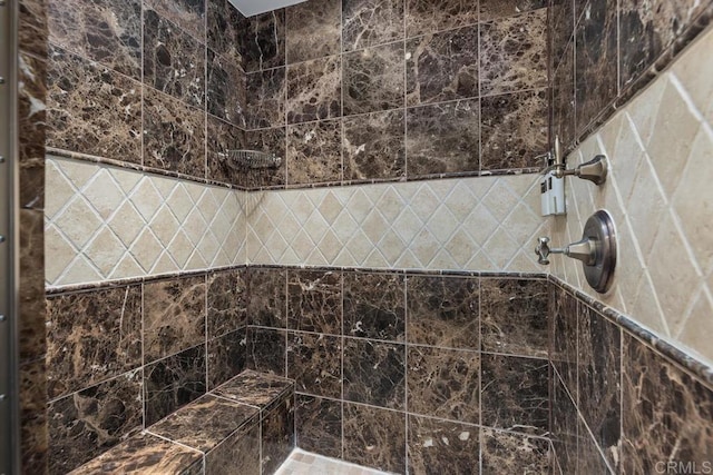 interior details featuring a tile shower