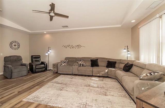 living room featuring hardwood / wood-style floors, a tray ceiling, and a wealth of natural light