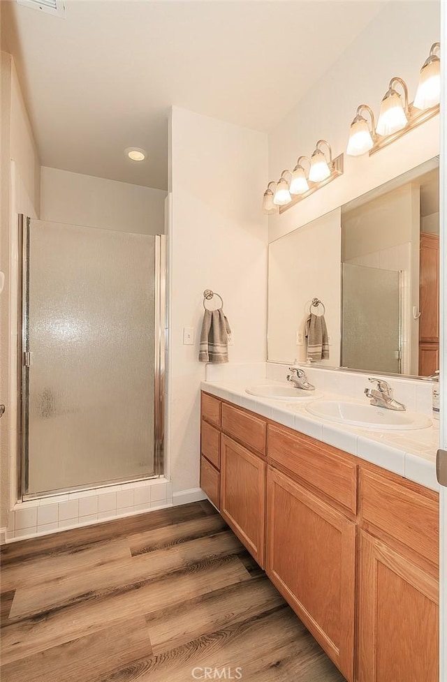 bathroom featuring walk in shower, vanity, and hardwood / wood-style floors