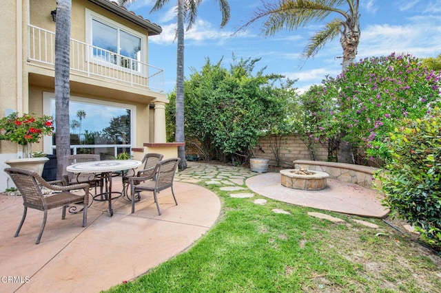 view of patio featuring a balcony and a fire pit