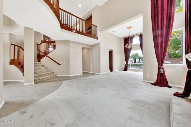 living room featuring light colored carpet, a high ceiling, and a chandelier