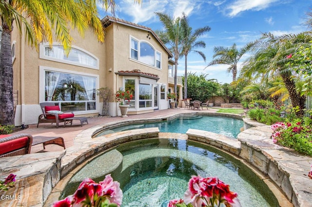 view of pool featuring an in ground hot tub and a patio