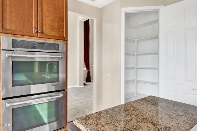 kitchen with double oven and light stone countertops