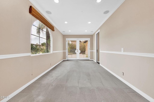 carpeted spare room featuring french doors and ornamental molding