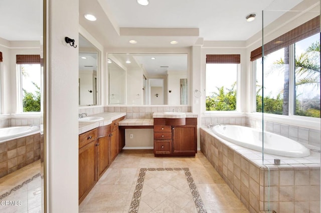 bathroom with a relaxing tiled tub, a wealth of natural light, and vanity