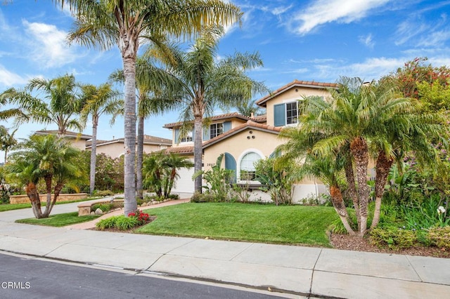 mediterranean / spanish-style house with a garage and a front yard