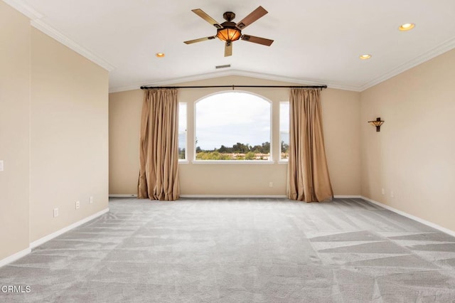 carpeted empty room with ceiling fan, crown molding, and vaulted ceiling