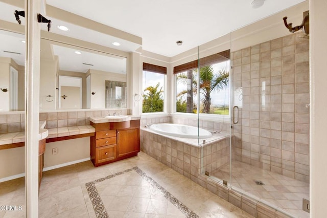 bathroom with tile patterned flooring, vanity, and shower with separate bathtub