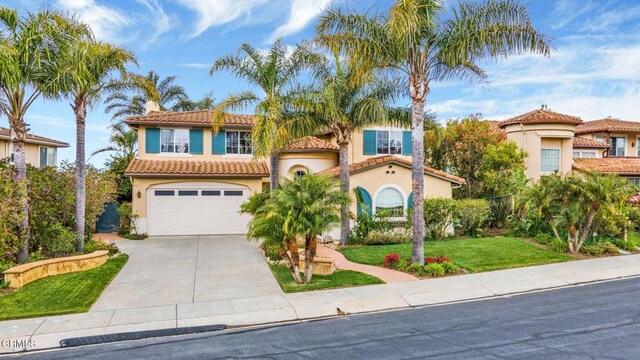 mediterranean / spanish-style house featuring a garage and a front lawn