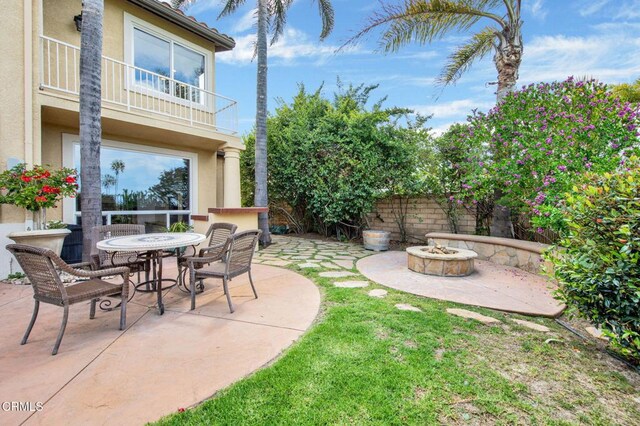 view of patio / terrace featuring a balcony and an outdoor fire pit