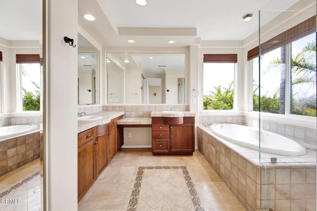 bathroom with a relaxing tiled tub and vanity