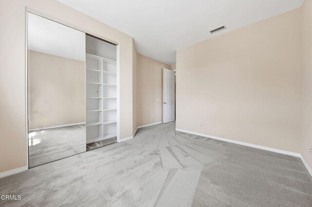 unfurnished room featuring light colored carpet