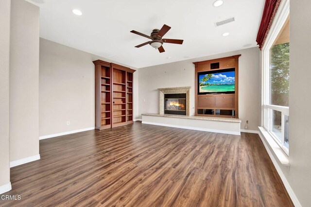 unfurnished living room featuring ceiling fan and dark hardwood / wood-style flooring