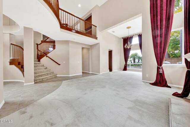 carpeted living room with a chandelier and a high ceiling