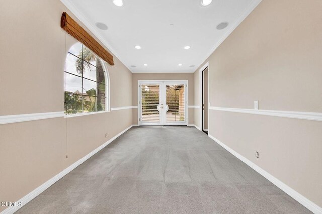 carpeted empty room with ornamental molding and french doors