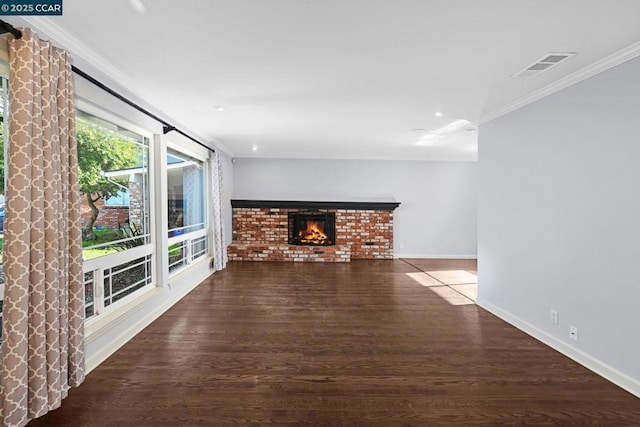 unfurnished living room with a brick fireplace, crown molding, and dark hardwood / wood-style floors