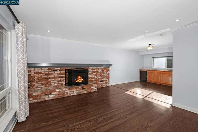 unfurnished living room with a brick fireplace, dark hardwood / wood-style flooring, and ornamental molding