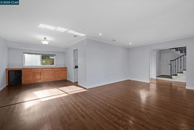 unfurnished living room with wine cooler, dark hardwood / wood-style flooring, and crown molding