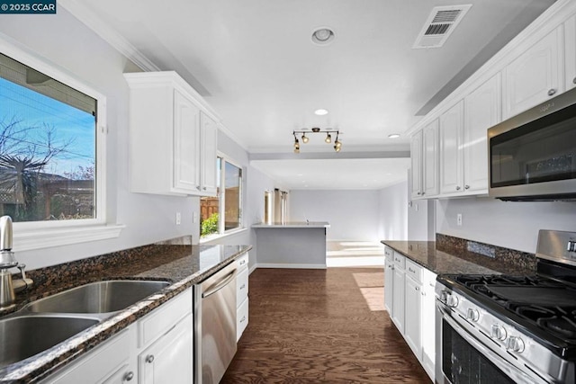 kitchen featuring sink, white cabinetry, appliances with stainless steel finishes, and dark stone counters